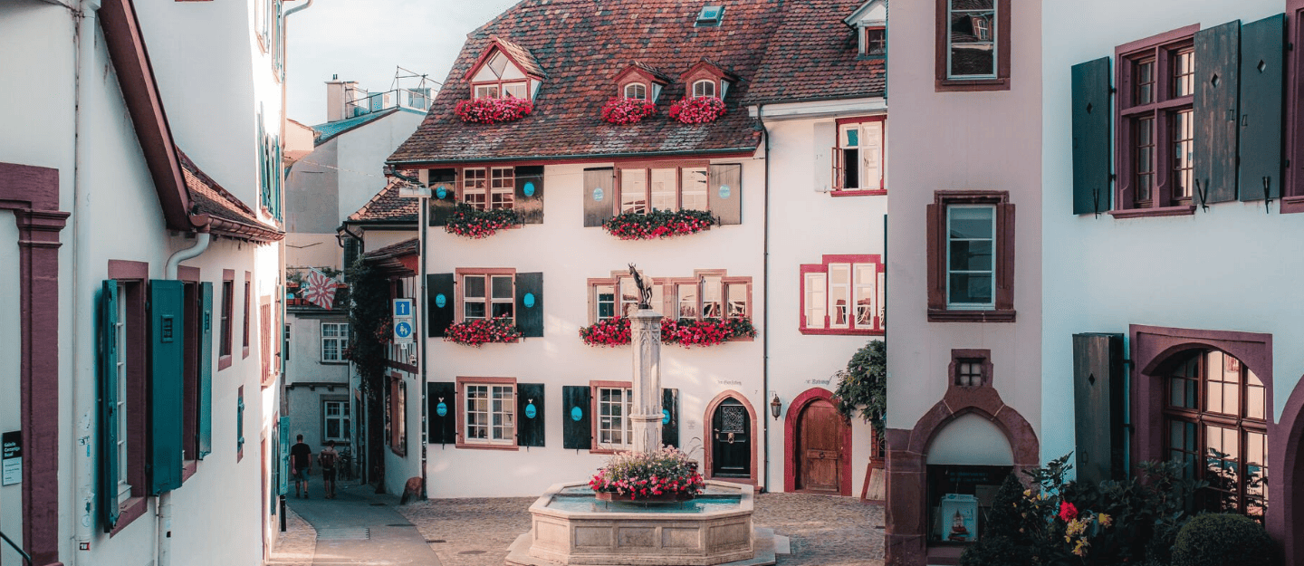 The illuminated Basel Christmas Market in Switzerland, showcasing wooden stalls and festive crowds.